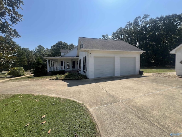 view of front of property with concrete driveway, a garage, covered porch, and roof with shingles