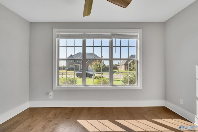 unfurnished room featuring ceiling fan, wood-type flooring, and plenty of natural light