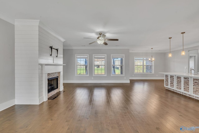 unfurnished living room with crown molding, a wealth of natural light, and dark hardwood / wood-style floors