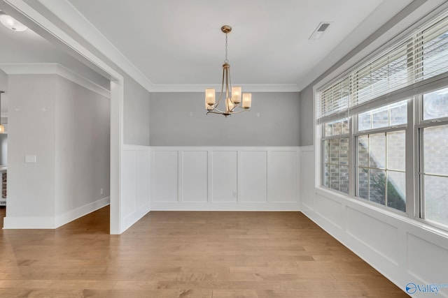 unfurnished dining area with crown molding, light hardwood / wood-style flooring, and a healthy amount of sunlight