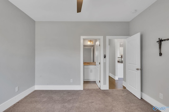 unfurnished bedroom featuring connected bathroom, ceiling fan, and light colored carpet