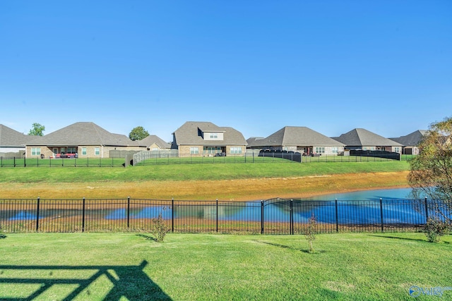 view of pool with a yard and a water view