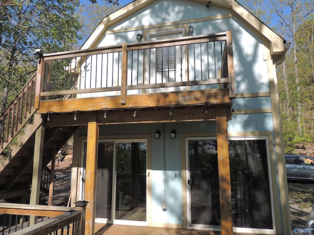 rear view of house featuring a wooden deck and stairway