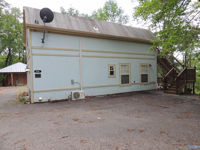 back of house with ac unit and stairs
