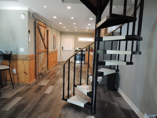 stairs featuring a barn door, wood finished floors, wainscoting, ornamental molding, and recessed lighting
