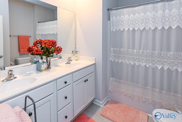 full bathroom featuring tile patterned floors, shower / tub combo with curtain, vanity, and toilet