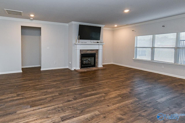 unfurnished living room with a fireplace, crown molding, and dark wood-type flooring