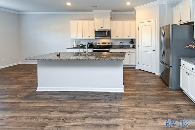 kitchen with dark stone countertops, sink, an island with sink, and appliances with stainless steel finishes