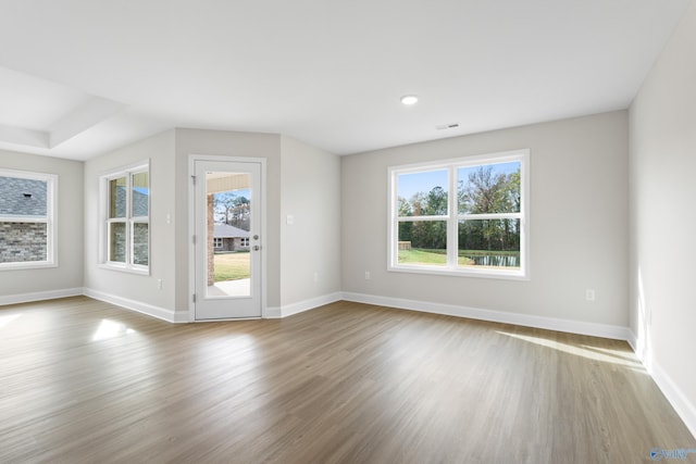 spare room with visible vents, baseboards, and wood finished floors