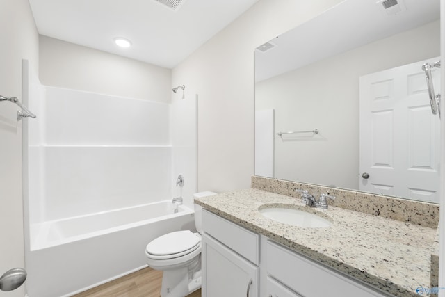 bathroom featuring toilet, wood finished floors, vanity, visible vents, and tub / shower combination