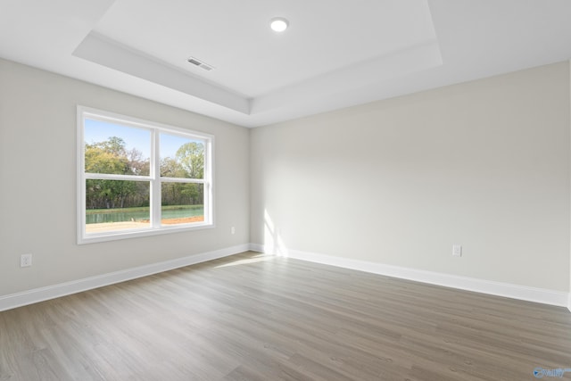 spare room featuring baseboards, visible vents, and a tray ceiling