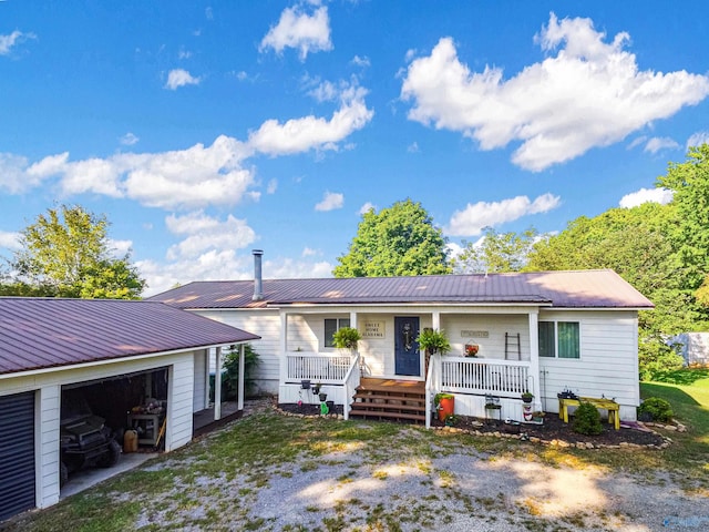 ranch-style house with a porch, an outbuilding, and a garage