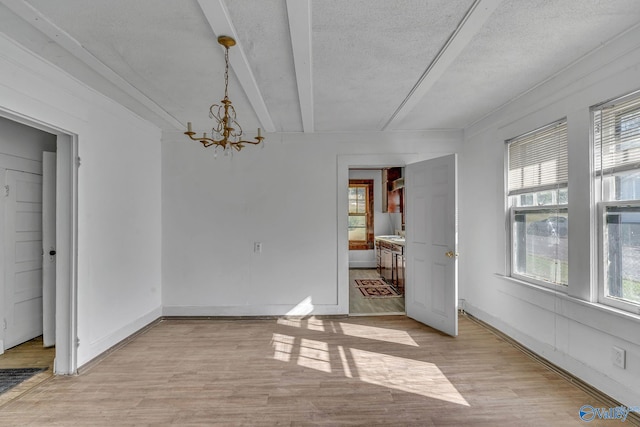 1011 Hermosa Ave, Gadsden, AL 35901 - unfurnished dining area featuring a healthy amount of sunlight, light wood-type flooring, a notable chandelier, and a textured ceiling