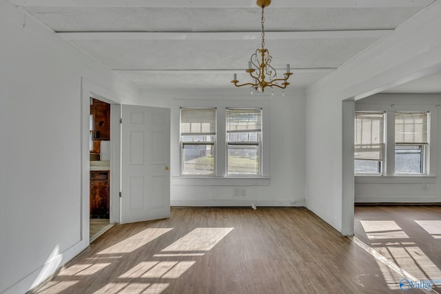 unfurnished dining area featuring wood-type flooring and an inviting chandelier