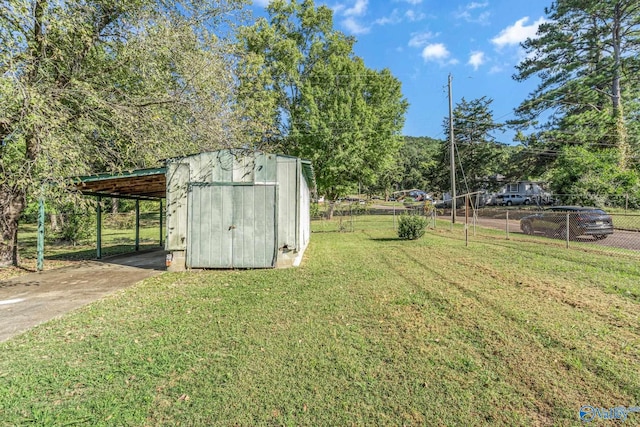 1011 Hermosa Ave, Gadsden, AL 35901 - view of yard featuring an attached carport, an outbuilding, a storage shed, driveway, and fence
