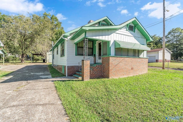 view of front facade with an outbuilding, a front yard, and a garage