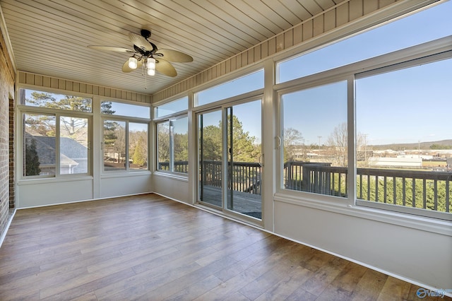 unfurnished sunroom with a wealth of natural light, wood ceiling, and ceiling fan