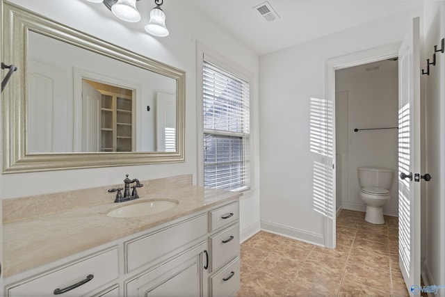 bathroom featuring baseboards, visible vents, toilet, tile patterned flooring, and vanity