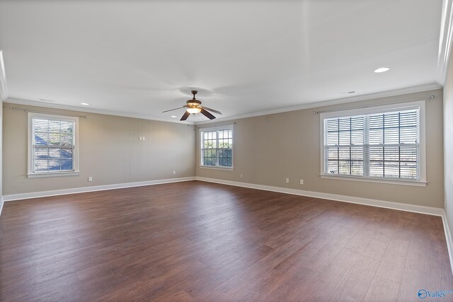 unfurnished room with ornamental molding, dark wood finished floors, and baseboards