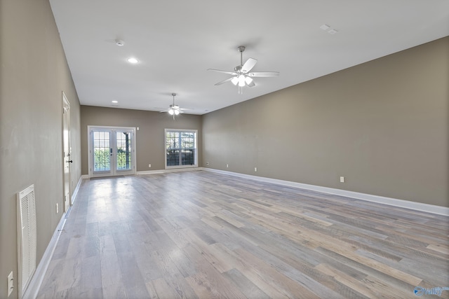 empty room featuring visible vents, baseboards, a ceiling fan, french doors, and light wood-style floors