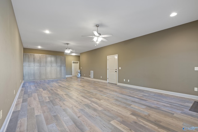 empty room with visible vents, ceiling fan, light wood-style flooring, and baseboards