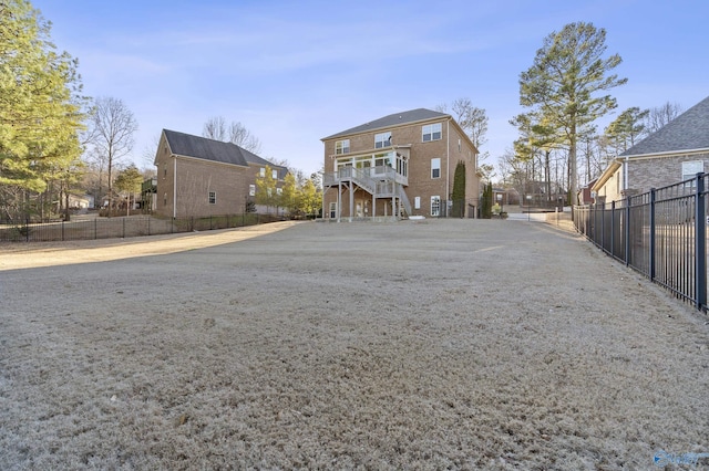 back of house with stairs, brick siding, and fence