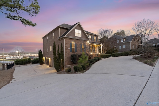 view of front facade with brick siding, driveway, and an attached garage