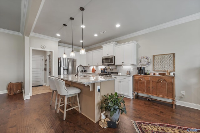 kitchen with crown molding, light stone countertops, white cabinets, and appliances with stainless steel finishes
