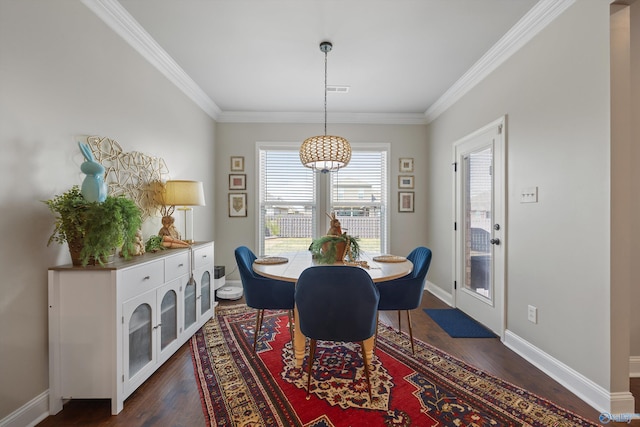 dining room with dark wood-type flooring, crown molding, and baseboards