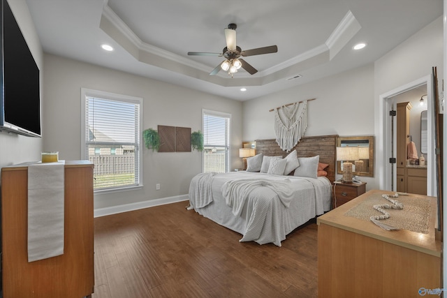 bedroom featuring dark wood-type flooring, a raised ceiling, recessed lighting, and ornamental molding