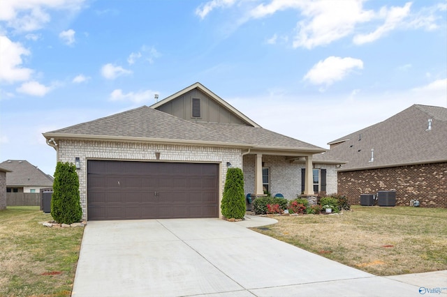 view of front of home with board and batten siding, central AC, a front yard, concrete driveway, and an attached garage
