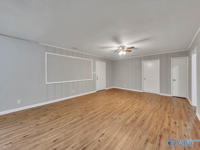 unfurnished room featuring light wood-type flooring, a ceiling fan, baseboards, and ornamental molding