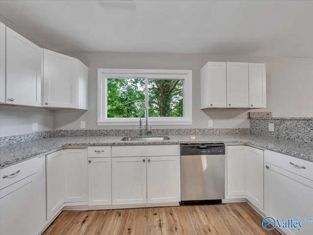 kitchen with a sink, stainless steel dishwasher, light wood-style flooring, and white cabinetry