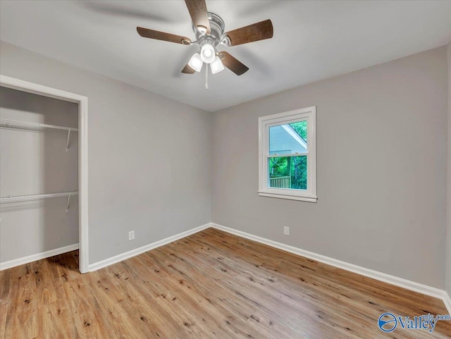 unfurnished bedroom with baseboards, a ceiling fan, a closet, and wood finished floors