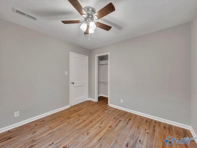 unfurnished bedroom featuring baseboards, visible vents, ceiling fan, and light wood finished floors