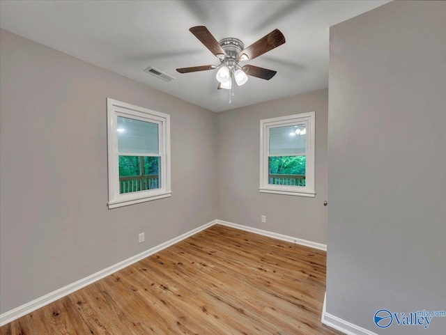 unfurnished room featuring visible vents, light wood-style flooring, ceiling fan, and baseboards