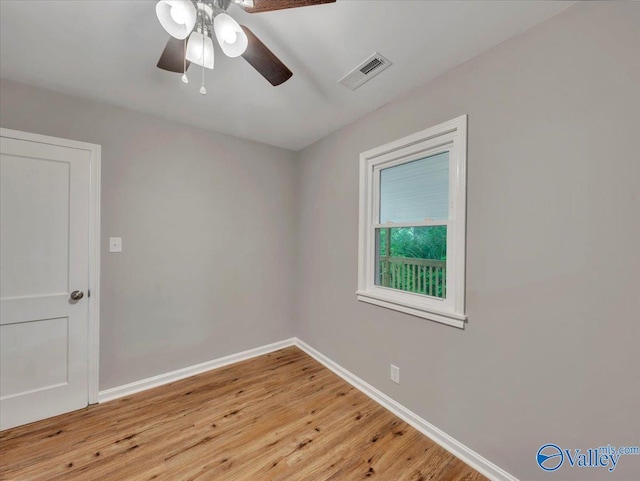 empty room featuring baseboards, ceiling fan, light wood-style flooring, and visible vents