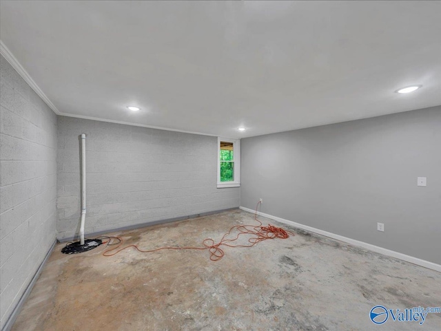 basement with concrete block wall, crown molding, and recessed lighting
