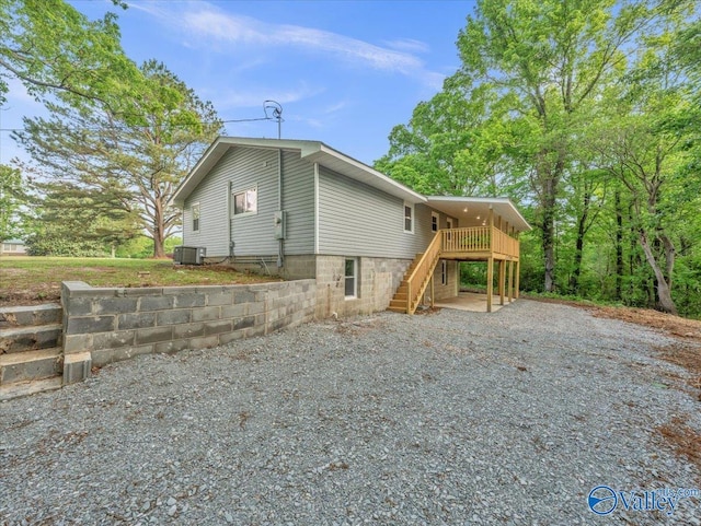 view of home's exterior featuring a wooden deck, stairs, and central AC unit
