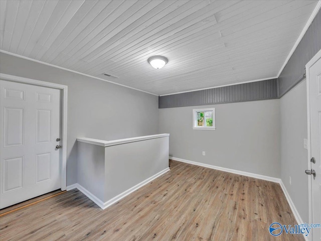 interior space with crown molding, baseboards, wood ceiling, and wood finished floors