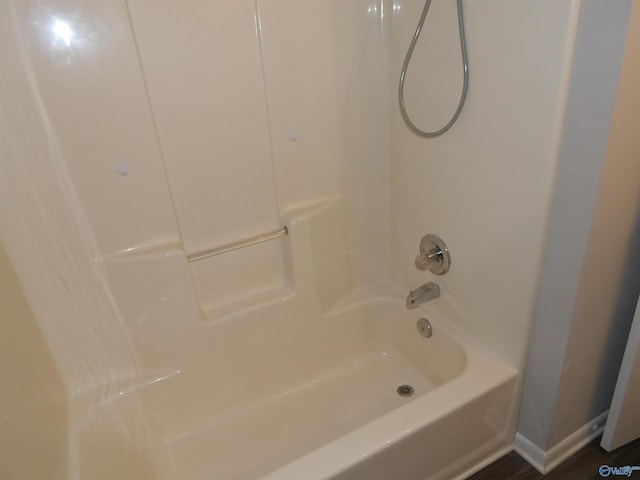 bathroom featuring hardwood / wood-style flooring and shower / washtub combination