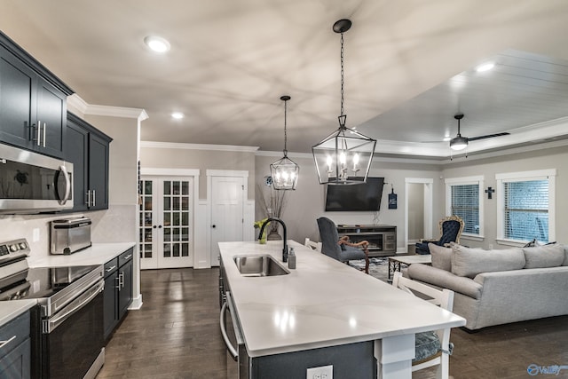 kitchen featuring dark wood-type flooring, sink, hanging light fixtures, an island with sink, and stainless steel appliances