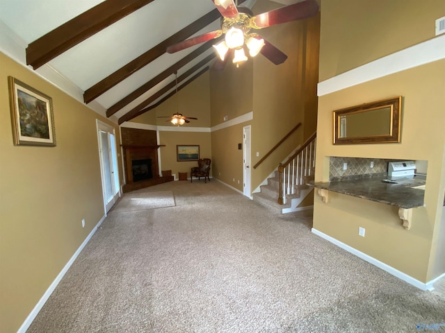 unfurnished living room with beamed ceiling, light carpet, high vaulted ceiling, and a fireplace