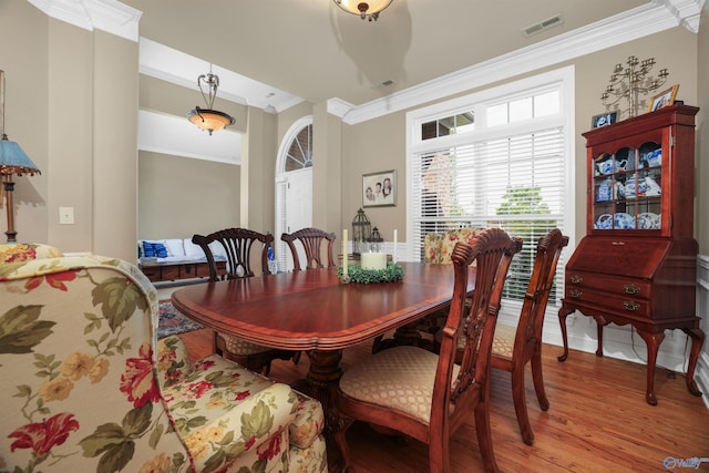 dining room with wood-type flooring and ornamental molding