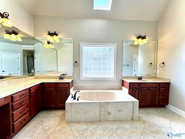 bathroom featuring tile patterned flooring, vanity, a skylight, and a tub