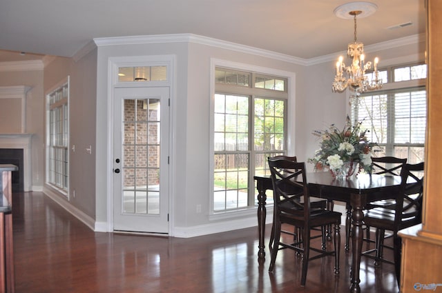 dining room featuring dark hardwood / wood-style flooring, a notable chandelier, ornamental molding, and plenty of natural light