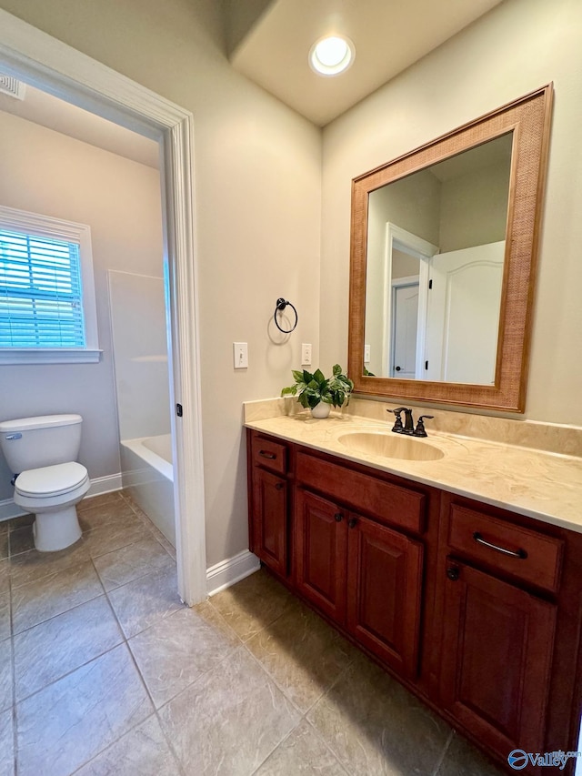 bathroom with toilet, vanity, and tile patterned flooring