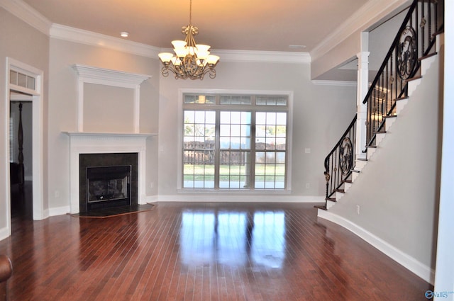 unfurnished living room featuring dark hardwood / wood-style flooring, a chandelier, and crown molding