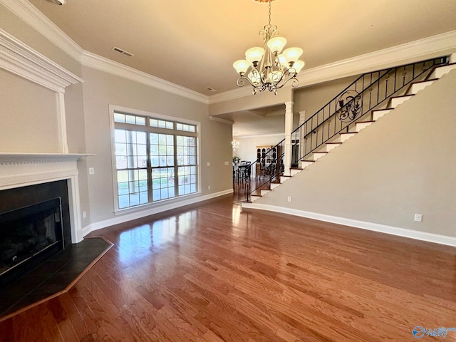 unfurnished living room with hardwood / wood-style flooring, an inviting chandelier, and ornamental molding