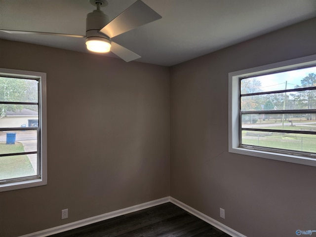 spare room with dark hardwood / wood-style flooring, a wealth of natural light, and ceiling fan